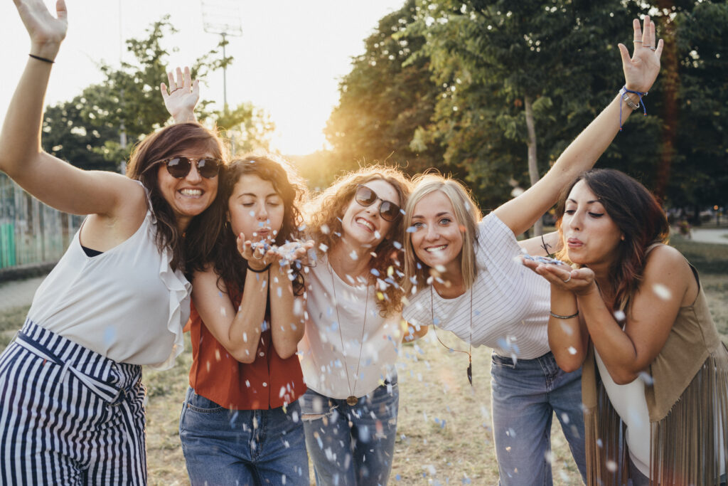 Friends having fun together with confetti at a party